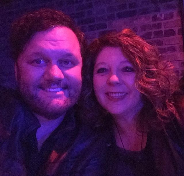 David Phelps in black jacket with his wife in black tops.